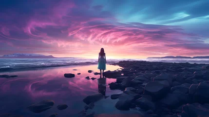 Fototapeten Woman walking along water's edge at sunset, with vibrant colors illuminating the sky in a tranquil landscape © photosaint