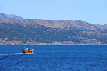 Sailing boat on the Adriatic sea. View of Podstrana, small coastal town in Croatia. 