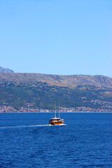 Sailing boat on the Adriatic sea. View of Podstrana, small coastal town in Croatia. 