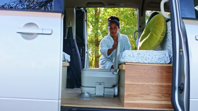 Woman in portable toilet embracing van life in New Zealand
