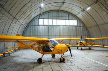 Yellow airplane glider in the hangar. 