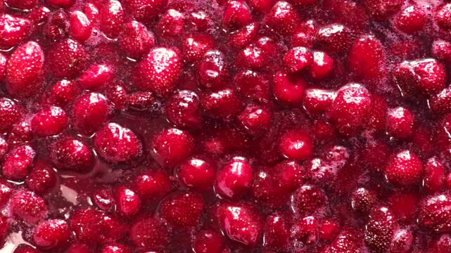 Fresh strawberry jam being stirred in a pot