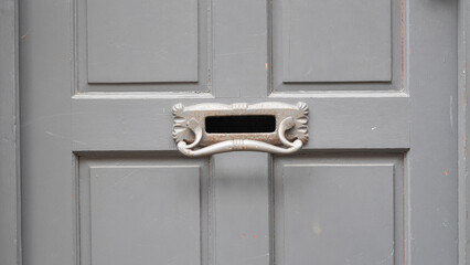 Closeup of English entrance door with brass letterbox and classic home style