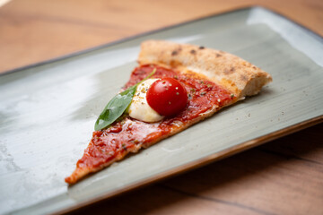 Single slice of Margherita pizza – side view