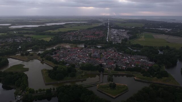Aerial shot of Naarden city houses surrounded by moats and greenery at sunset