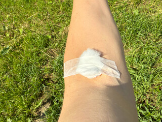 Arm of man has cotton swab to close the wound after blood test. Cotton ball with plaster cover skin...