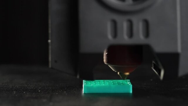 Timelapse close-up of a 3D printer printing a cube. Assistant objects made of plastic. High quality 4k footage