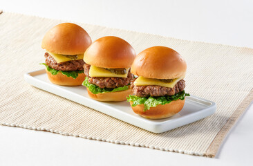 US Angus Beef Sliders or Mini Cheeseburgers on White Platter, each with a juicy patty, melted...