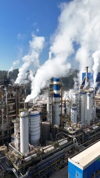 Vis&atilde;o a&eacute;rea de ind&uacute;stria de papel e celulose com chamin&eacute;s e caldeiras liberando fuma&ccedil;a, impacto ambiental vis&iacute;vel e poluentes no ar, destacando processos industriais complexos