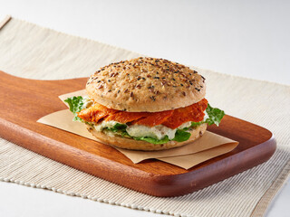 Chicken Tandoori Chicken Tandoori Multi grain Sandwich with lettuce, and creamy sauce on wooden cutting board side view of lunch menu
