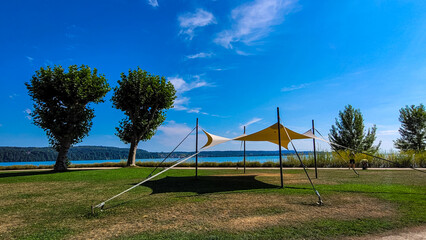 Fototapeta premium A tent for camping and relaxing on the meadow on the beach of a lake, river or sea on a sunny day. Travel topic.