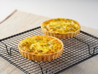 Savory Four Cheese Quiche on Cooling Rack Side View of Golden Individual Tarts