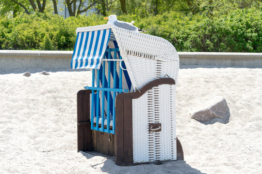 Seagull on a beautiful beach chair in the sand on a sunny, relaxed day on the coast of Mecklenburg Western Pomerania, East Germany
