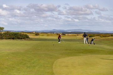 a golfer playing at the old course in st andrews in Scotland