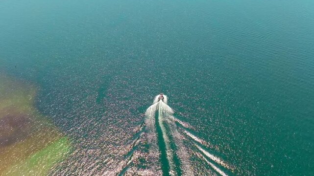 Wake boat surf boat driving sunny day aerial drone slow motion