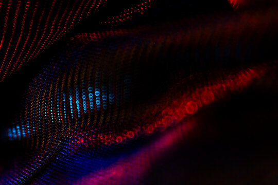 Abstract wave of colorful bokeh lights in red and blue tones – vibrant glowing particles in motion for digital design, technology, energy, AI, science, and creative visual backgrounds