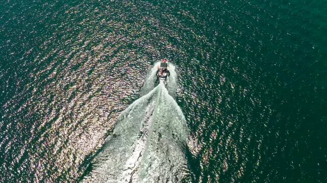 Wake boat surf boat driving sunny day aerial drone slow motion