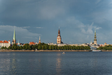 Historic skyline of Riga old town with church spires, cathedral, and waterfront view across river...