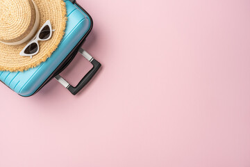 Blue suitcase displays a straw hat and sunglasses, set against a pink background. Perfect summer...