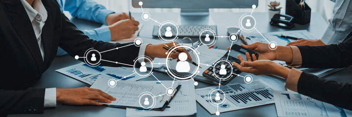 Professionals gather around a meeting table, discussing strategies and fostering connections...