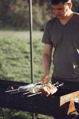 Grilling Meat Skewers over Open Flames in Outdoors Backyard Setting