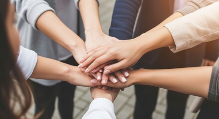A diverse group of people join hands together in a show of unity and teamwork