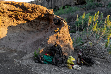 Boulder climbing gear at the base of a rugged rock
