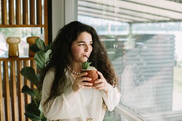 Young woman enjoying a refreshing drink at a cafe