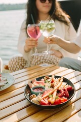 Friends enjoying drinks and charcuterie board by the water