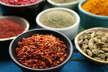 Different aromatic spices on blue tablecloth, closeup
