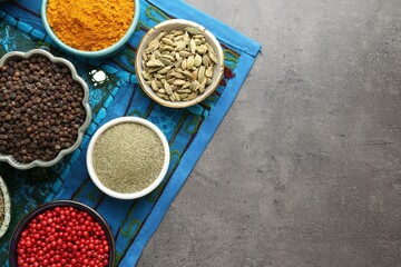 Different aromatic spices on grey table, flat lay. Space for text