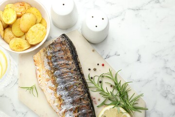 Homemade seafood dish. Tasty roasted mackerel with spices and potatoes on white marble table, flat lay. Space for text