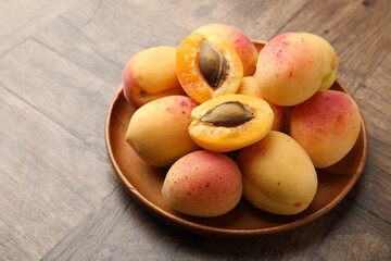 Many fresh apricots on wooden table, closeup