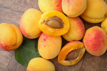 Many fresh apricots on wooden table, flat lay