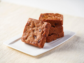 Square Rum and Dried Fruit Cookies in rectangular plate side view of Cafe Dessert