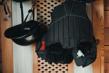 Protective Equestrian Gear Hanging in a Wooden Locker Ready for Horseback Riding