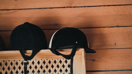 Equestrian Helmets Displayed on Wooden Shelf Inside Stable