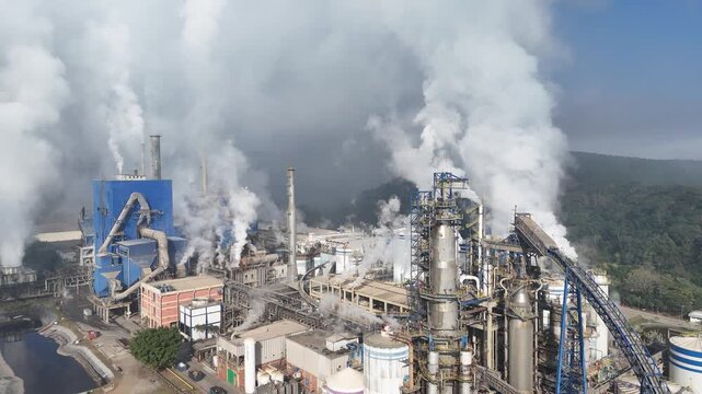 Vis&atilde;o a&eacute;rea parque industrial de papel e celulose com grande estrutura, chamin&eacute;s ativas e caldeiras. Evidencia-se o impacto ambiental e a escala produtiva
