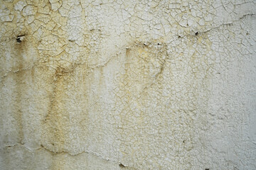 Peeling paint on a dirty white wall