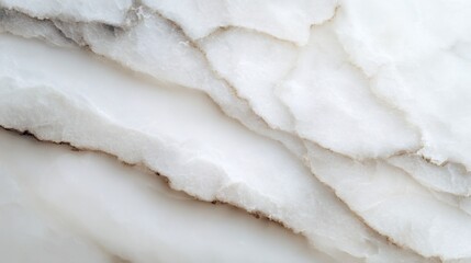 Close up of translucent white marble with delicate brown veining and layered texture