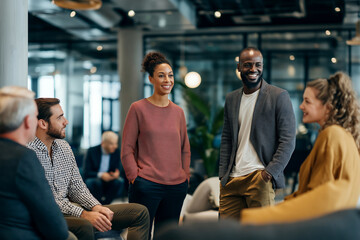 Team Collaboration in Modern Office: A diverse group of colleagues engaged in a lively discussion in a bright, modern office environment, fostering collaboration and teamwork.