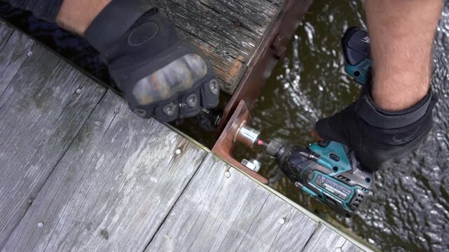man assembling two pieces of dock
