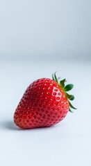 Vibrant Red Strawberry with Green Stem on White Surface