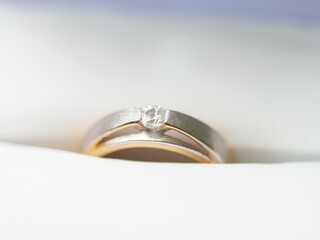 Close Up Elegant Diamond Ring with Gold Band on White Fabric