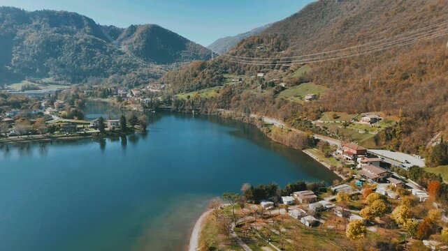 Drone tour over Lake Idro in Italy, revealing crystal-clear waters, forested slopes, and rural towns
