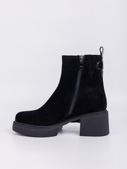 Discover our fashionable black suede ankle boots designed with a chunky heel, perfect for elevating...