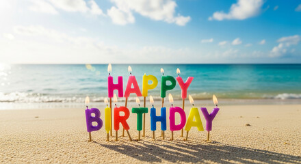 Colorful birthday candles spelling "Happy Birthday" on sandy beach with ocean background, signifying celebration, joy, and summer vacation