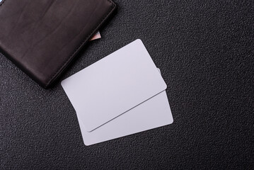 The white plastic card as a symbol of cashless payments on the background of cash paper money of...