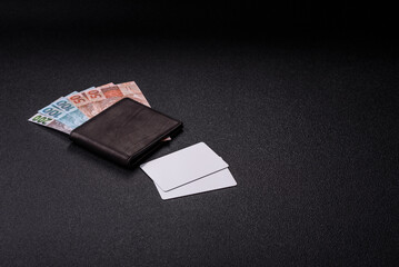 The white plastic card as a symbol of cashless payments on the background of cash paper money of...
