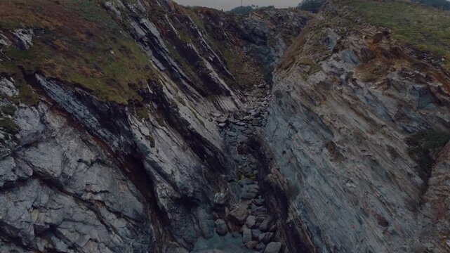 A breathtaking drone view of the rugged sea cliffs in Viav&eacute;lez, El Franco, Spain, showcasing the dramatic coastline and the deep blue ocean below.